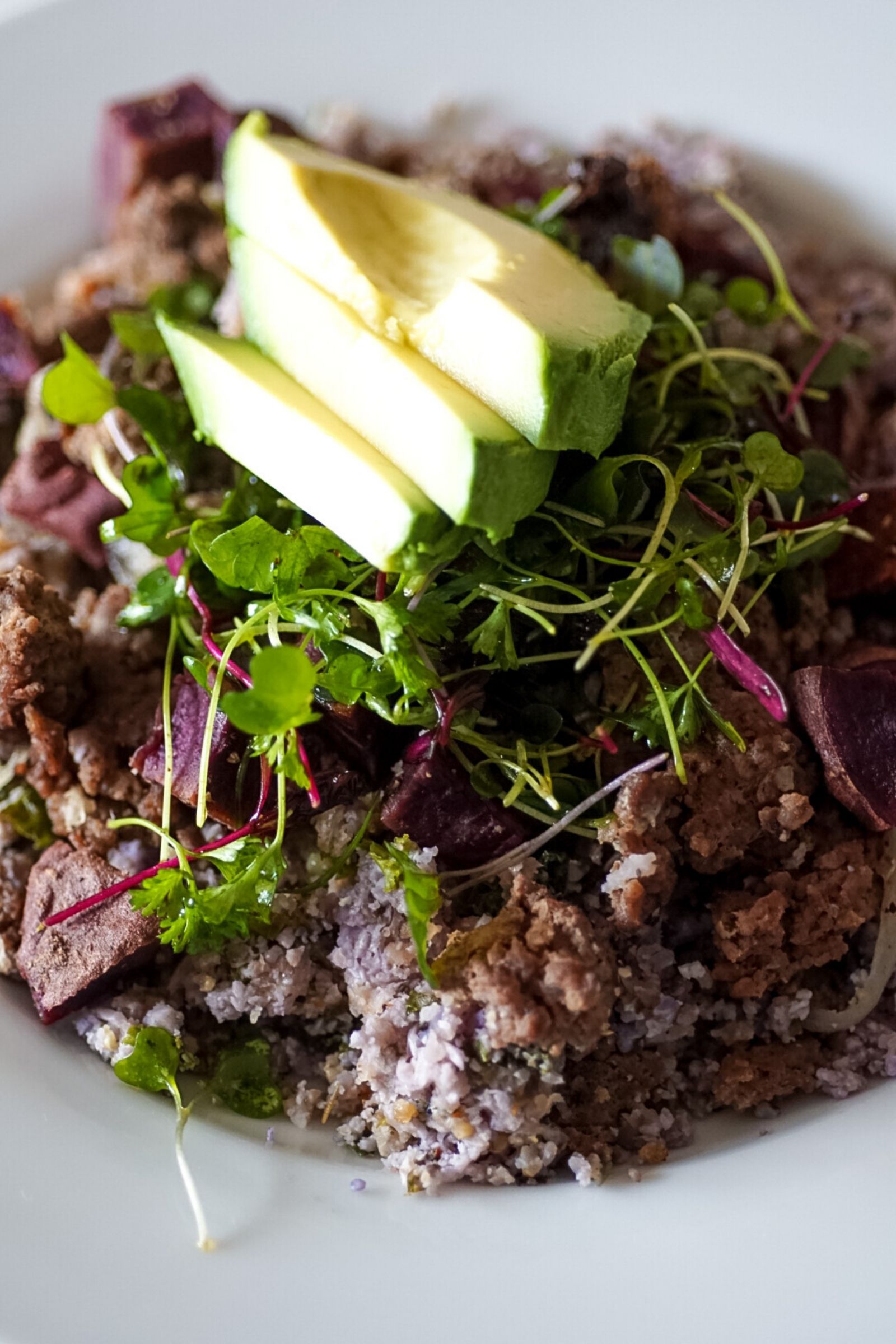 purple cauliflower rice bowl with ground venison, purple potatoes, microgreens and sundried tomatoes