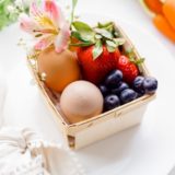 Easter breakfast baskets with fruit and hard boiled eggs that kids can decorate. | Canastitas de fruta y huevos cocidos para decorar